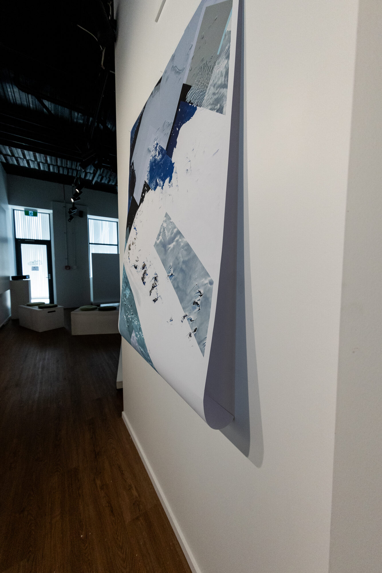 Detail — a plate curling off the wall, the room visible beyond