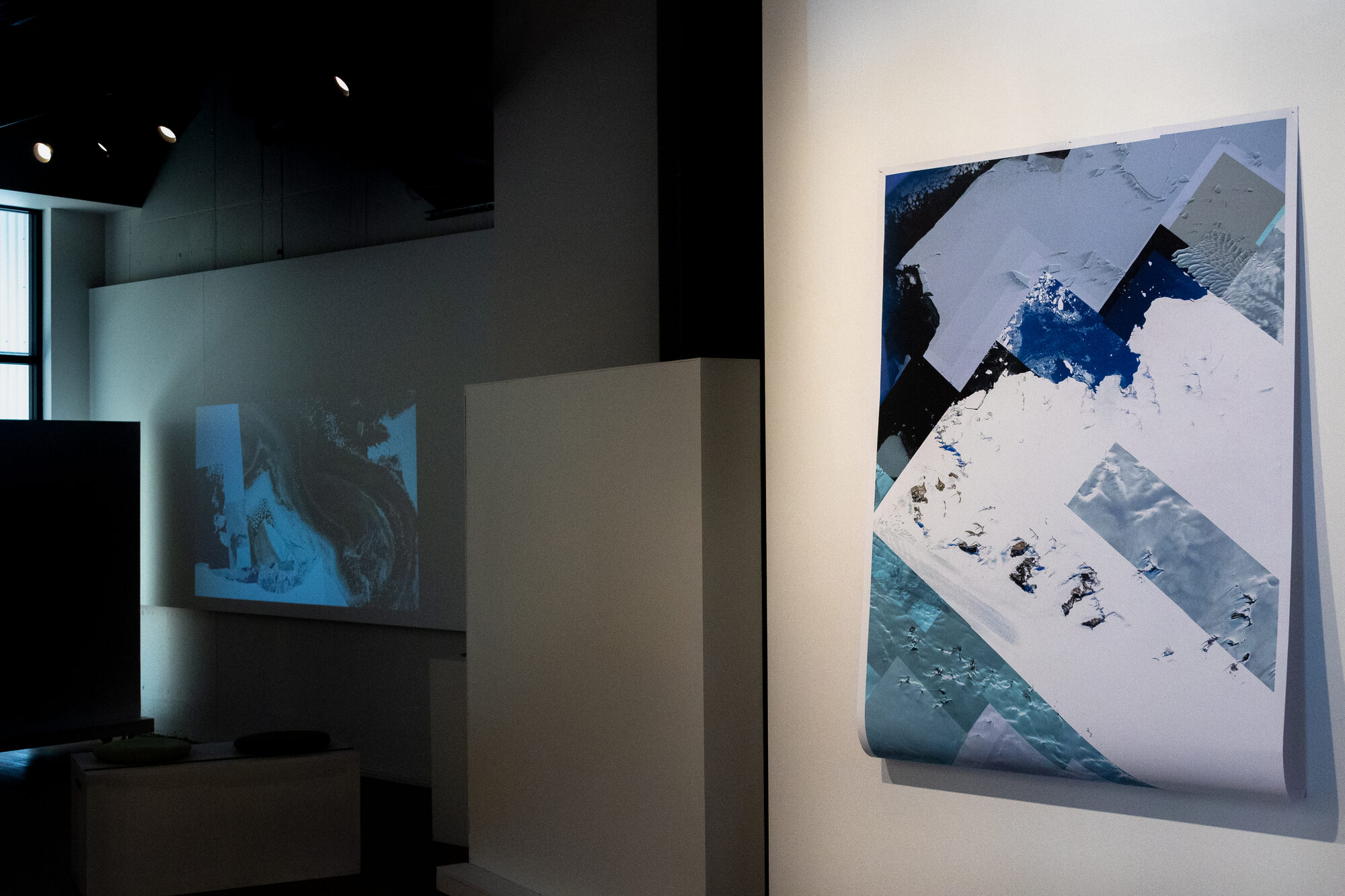 The projection lighting the far wall, a print lit at the right